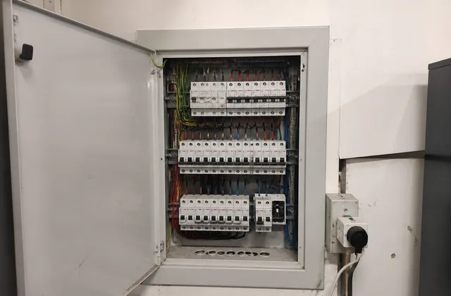 Open electrical switchboard photographed before maintenance at a Carlton job site.